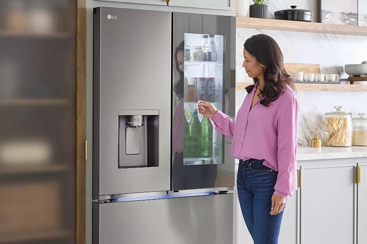 A woman knocking on the window of the LG InstaView refrigerator