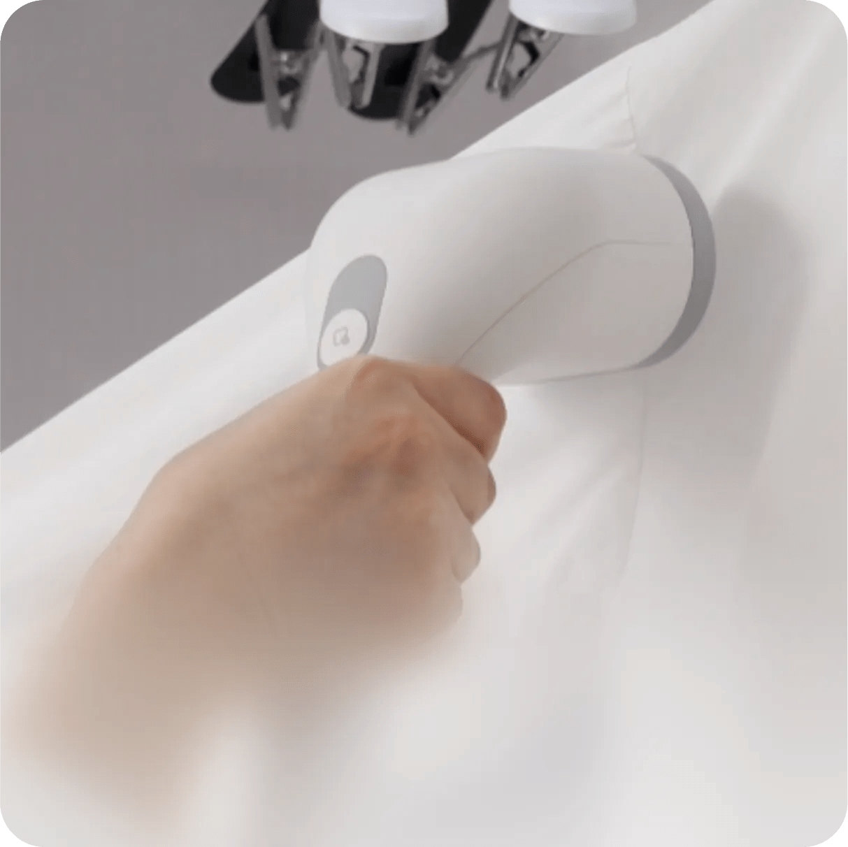 A hand uses the LG Styler®'s Built-in HandySteamer™ to steam the seams of a fabric.