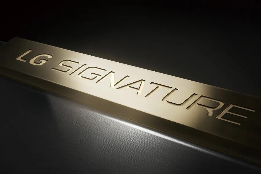 LG SIGNATURE embossed brass logo in brushed metal finish, close-up view.