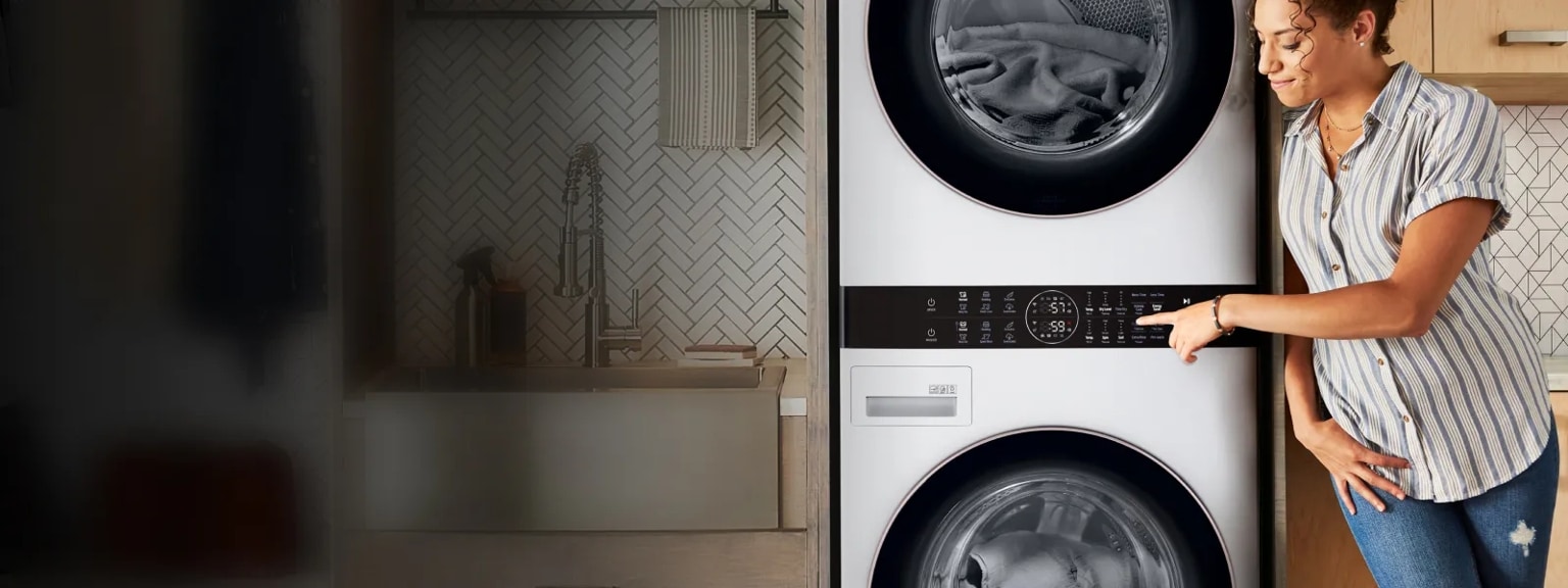 A woman presses a button on the Center Control® Panel of her LG WashTower™.
