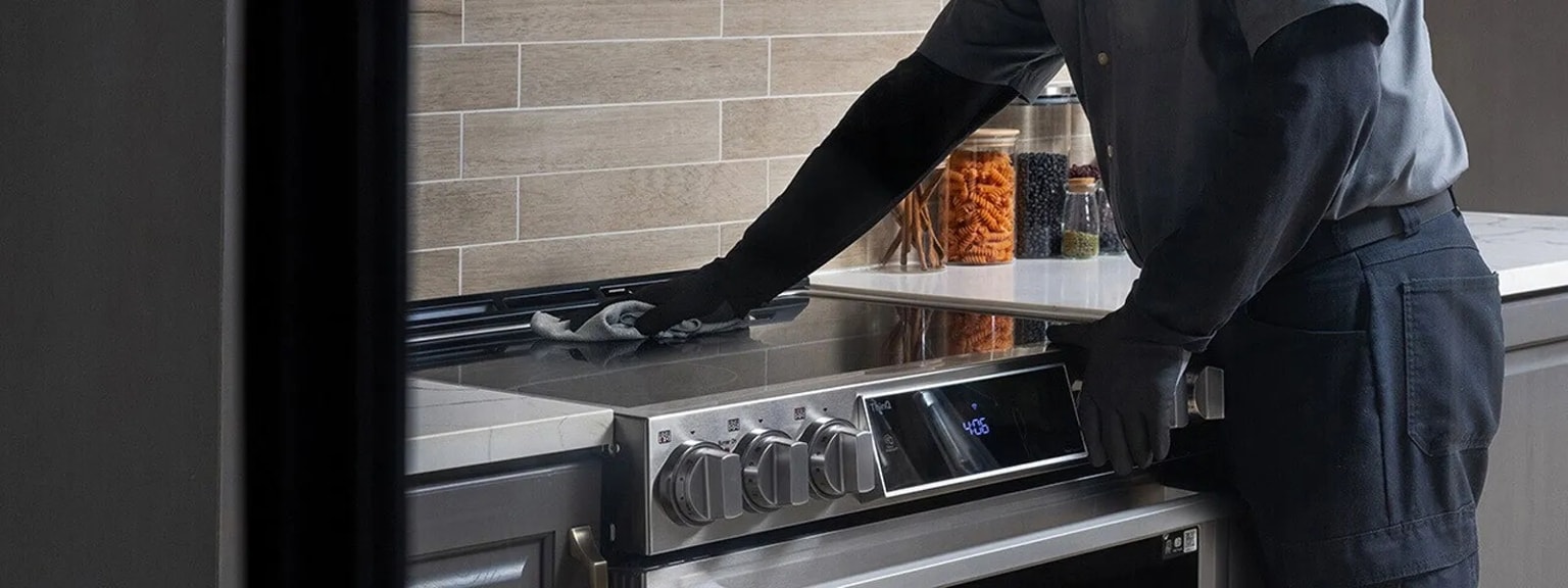 Contractor completing installation of new range and giving the cooktop a final shine. 