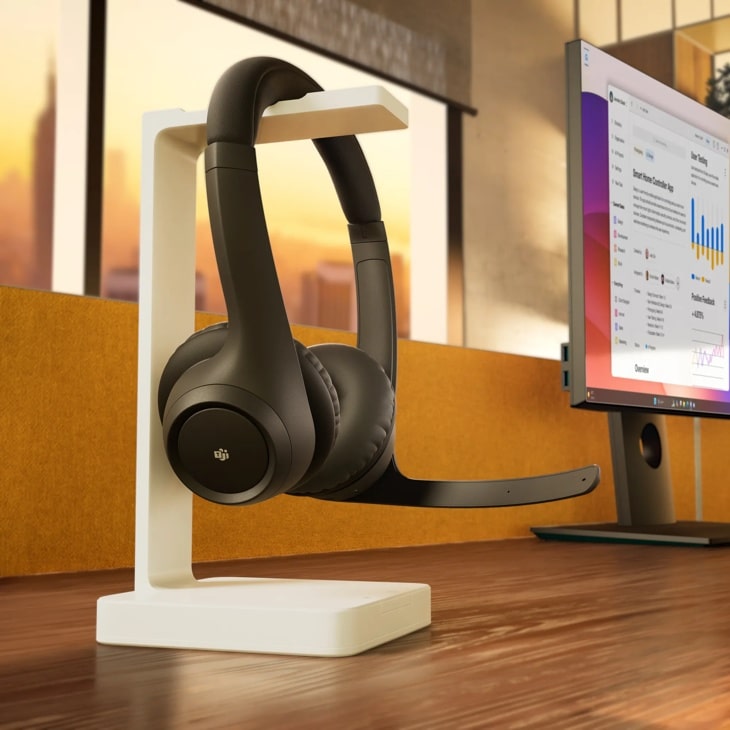 981001450 wireless headset with microphone on white stand next to computer monitor displaying analytics dashboard - Lifestyle Setup