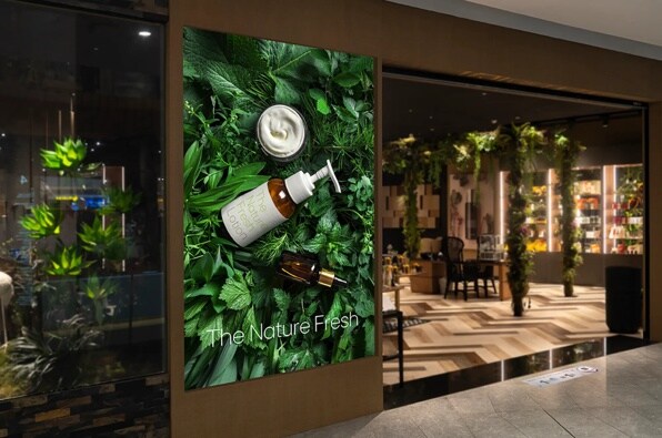 Advertisement with skincare products on a bed of green leaves, with text "The Nature Fresh."

