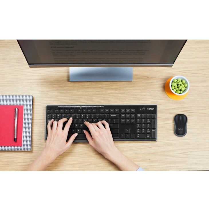 Logitech 920004536 keyboard on wooden desk with monitor, wireless mouse, notebook, and small bowl of edamame - Top View