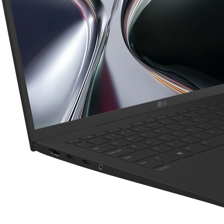 LG Gram 15Z95U-H.AU87U1 Laptop showing keyboard and display with abstract metallic wallpaper - Side Angle
