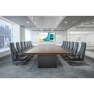Modern conference room with a long table, black chairs, and a large digital display.