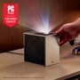 PU615U Projector with PC Mag Editors Choice award badge displaying colorful light beam projection while hand adjusts the compact cube design
