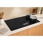 LG CBIU3639BE Cooktop with black glass surface and two pots in modern kitchen setting