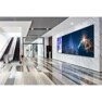Modern building lobby with escalators and digital displays on the wall.