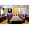 Modern conference room with a U-shaped table and digital screen displaying a presentation.