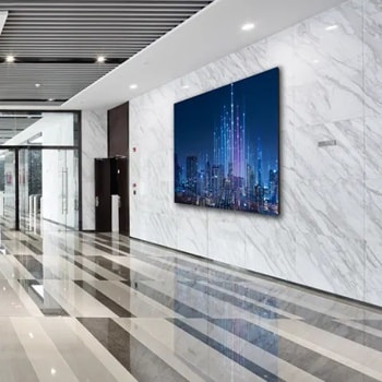 Sleek building lobby with escalator, polished striped floor, and large digital cityscape display.1