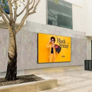 Mall interior with a Black Friday advertisement showing a person in a yellow suit holding shopping bags.1