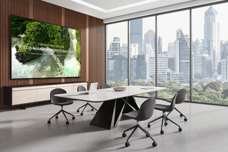 Modern conference room with a large screen and city skyline view through windows.