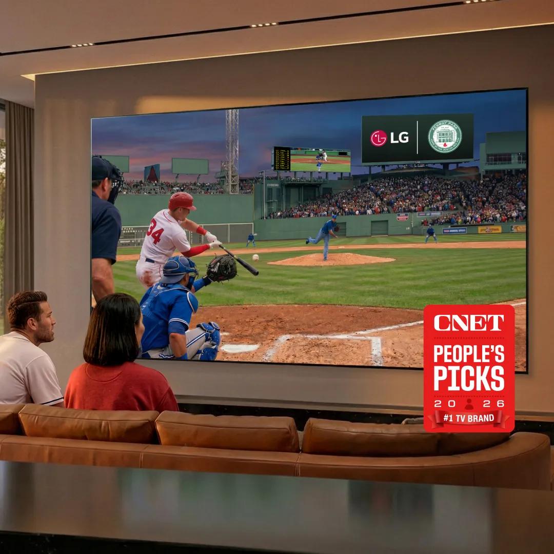 Friends cheer on a couch at night in a backyard lit by string lights, watching a soccer match on a portable LG TV on a stand, with the text ‘So free. So ME.’