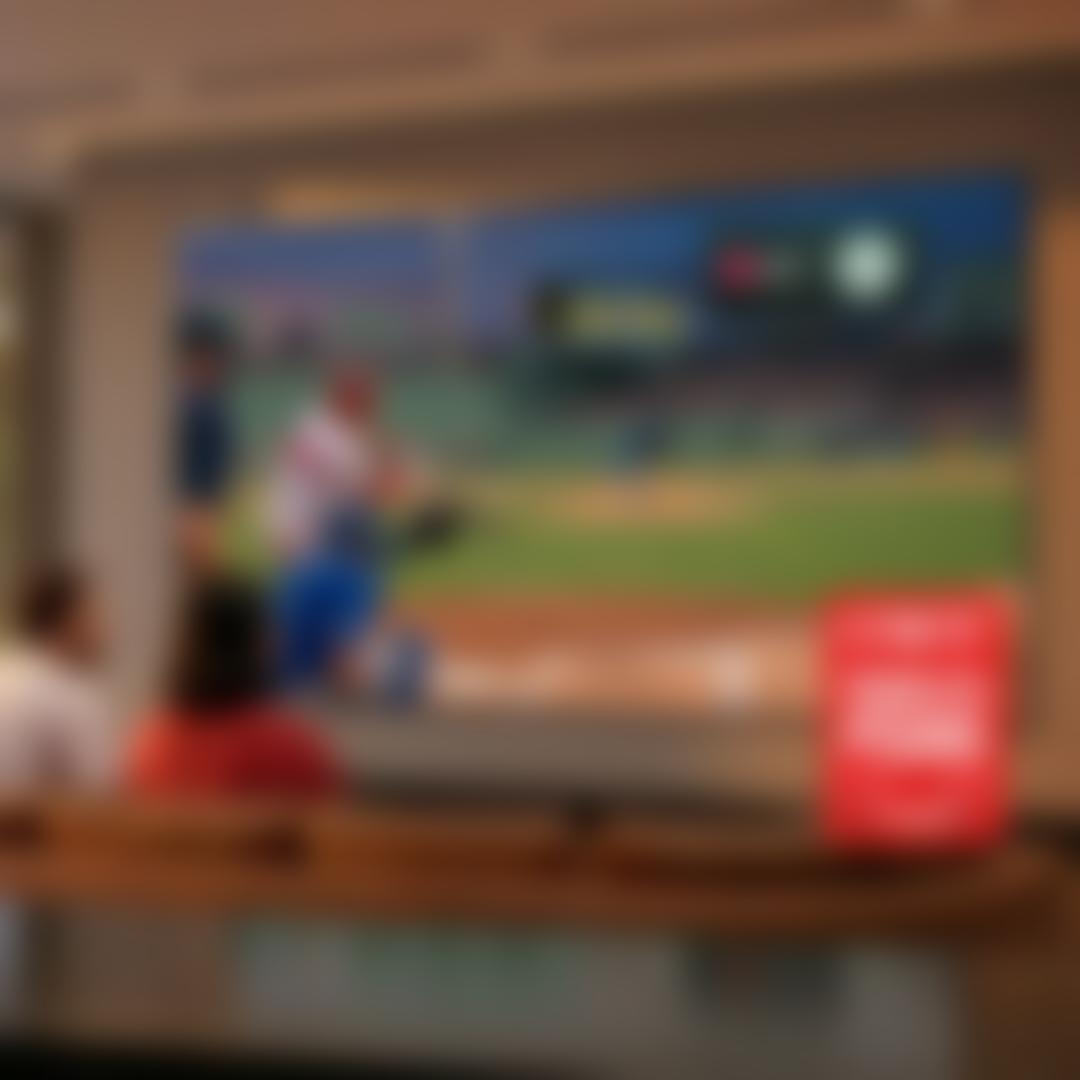 Friends cheer on a couch at night in a backyard lit by string lights, watching a soccer match on a portable LG TV on a stand, with the text ‘So free. So ME.’