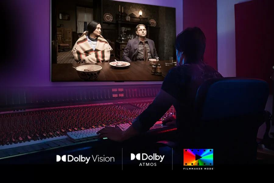 115QNED92BU LG QNED evo TV showing cinematic scene on screen with person viewing in professional studio with Dolby Vision, Dolby Atmos, and Filmmaker Mode logos