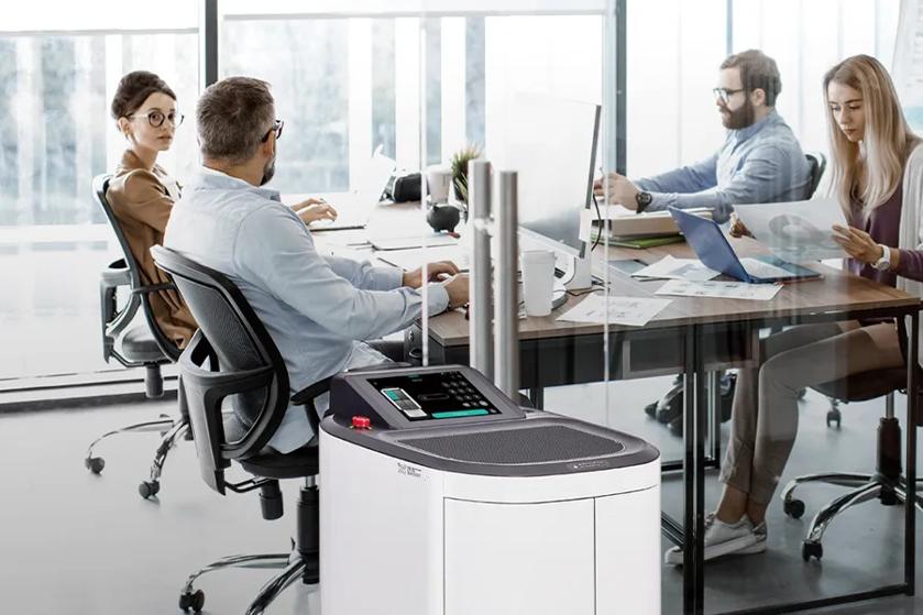 CLOi ServeBot rolling past several businesspeople working at their desks.