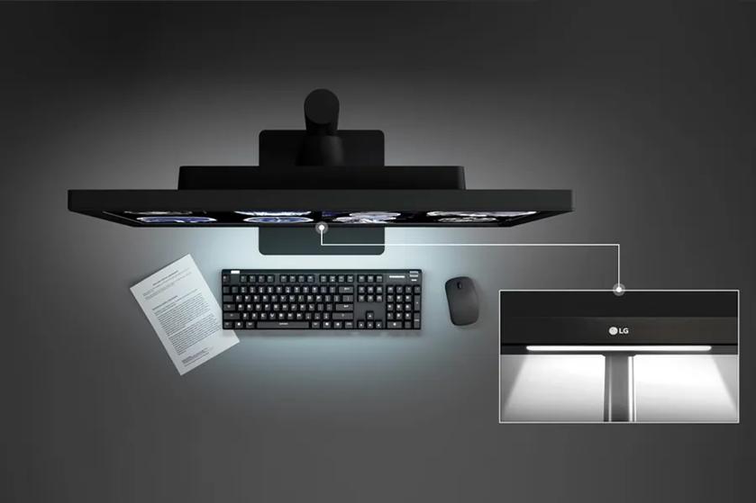 The image shows a diagnostic monitor setup from LG, positioned on a desk with a keyboard. The monitor displays grayscale medical imagery. A rectangular inset focuses on the front of the monitor where an illuminated LED strip is visible near the top edge, emphasizing the monitor's lighting feature.