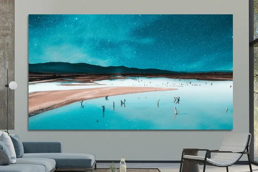 Large Digital display of a desert landscape with a reflective water body under a starry sky in a modern room.