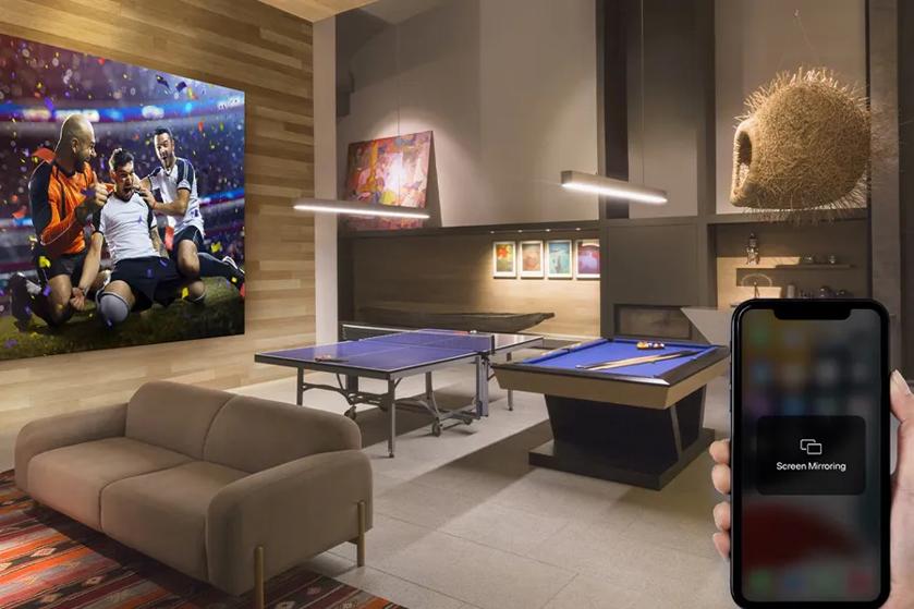 Entertainment room with a soccer photo, ping pong table, pool table, and screen mirroring on a smartphone.