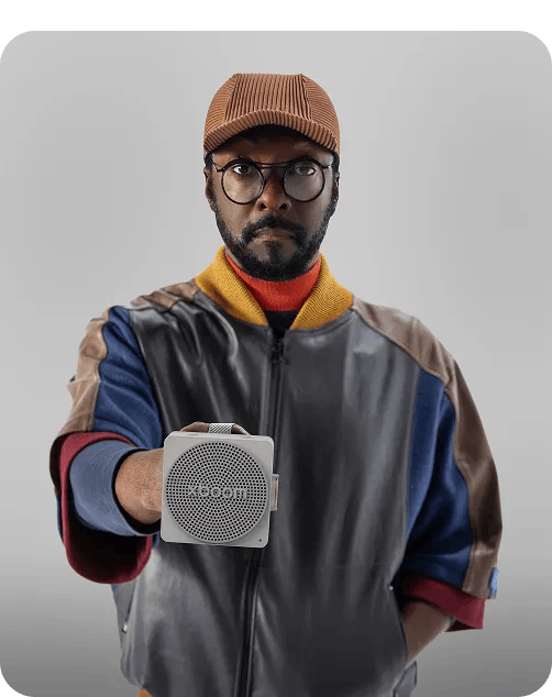 Will.i.am looking down at xboom speaker in his hands