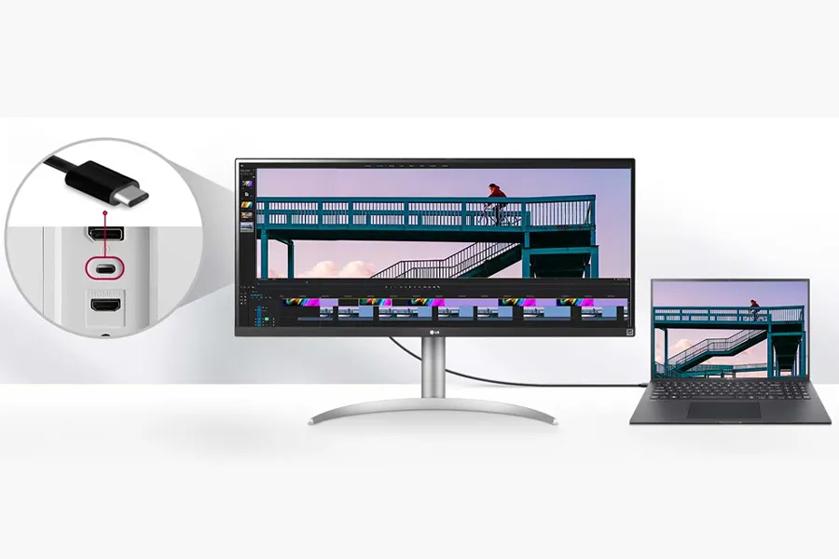 A widescreen monitor and laptop displaying the same image of a cyclist on a bridge, with a close-up of monitor connectivity ports showing USB-C and HDMI.