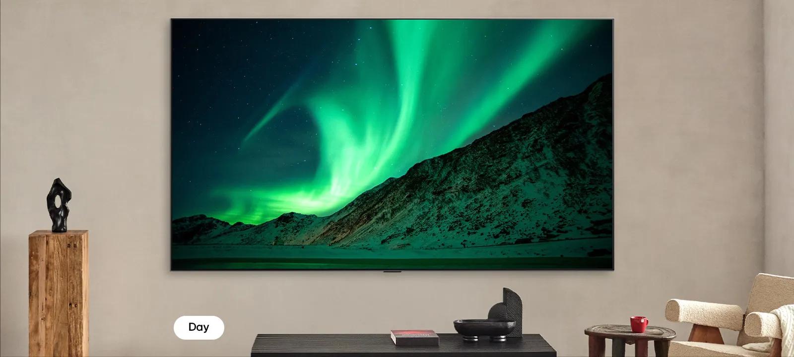 A TV screen showing the northern lights over mountains, split down the middle to compare brightness and contrast in day and night modes.