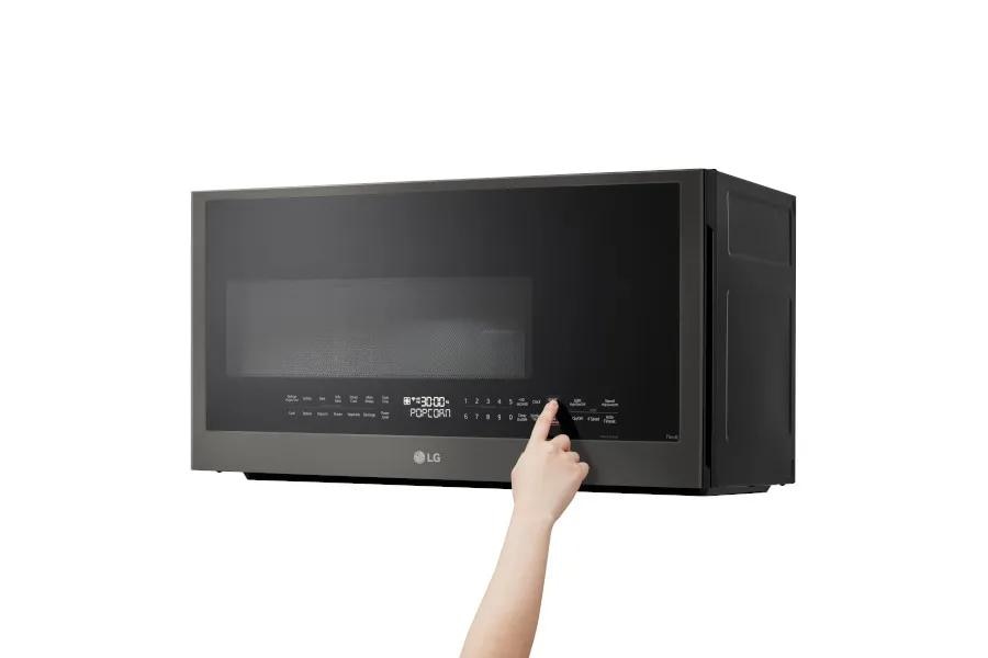 LG MVEL2035Z Over-the-Range Microwave with sleek black stainless finish showing person pressing control panel button
