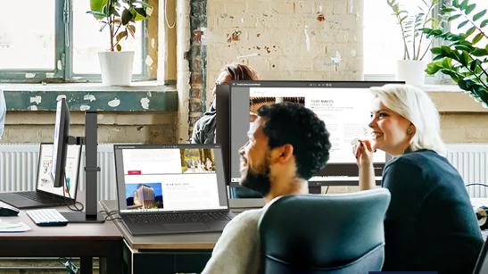 Young professionals sit in an office with LG newsletters displayed on their LG monitors and gram laptops.